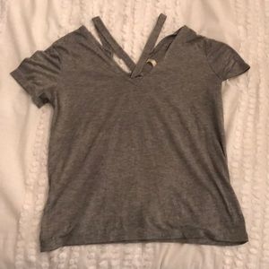 gray shirt with a cross at the neck